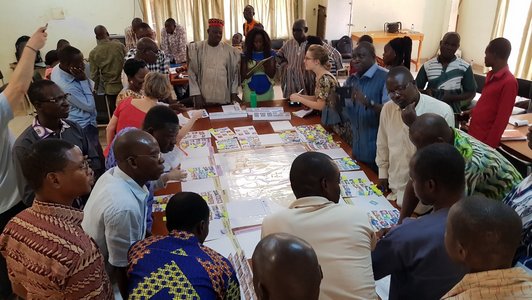 Participants of the workshop sitting around a table and working on the policy simulation