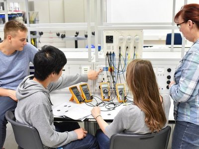 Young people in the company training center, during electrical engineering training.