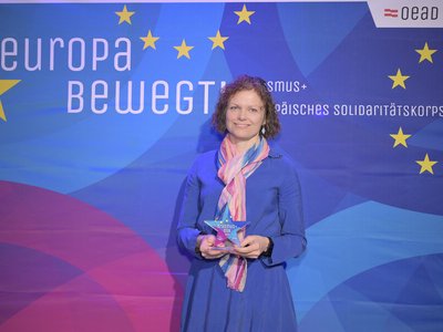 Frau mit Locken hält Preis