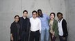 Group of alumni in front of a concrete wall