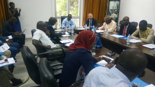 Group of people sitting around a table, most of them wiriting