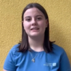 Eine junge Frau mit blauem Shirt blickt in die Kamera