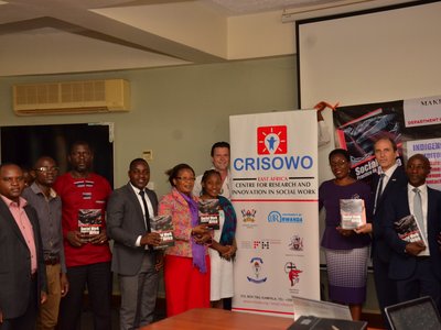 Group of people posing for a group picture next to a CRISOWO poster