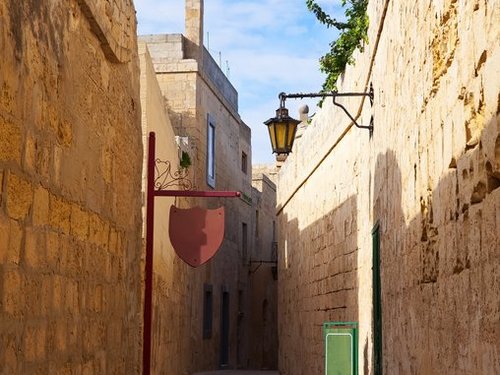 eine enge Gasse eingerahmt von hohen Steinmauern