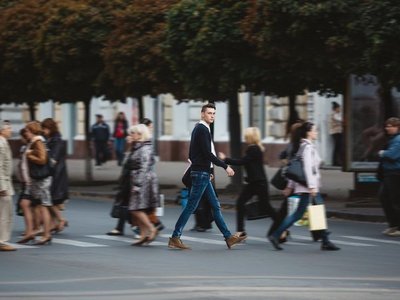 Zahlreiche Menschen überqueren Zebrastreifen in der Stadt