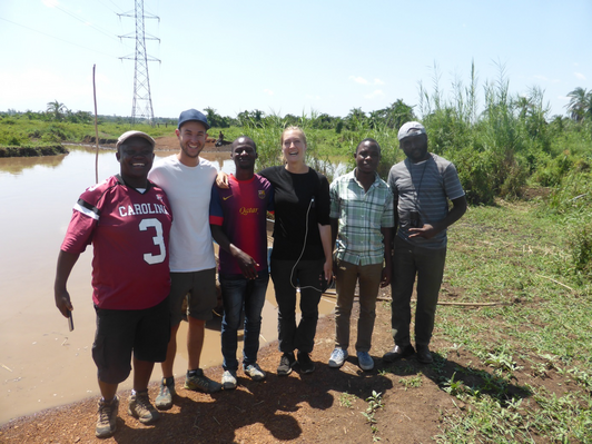 Group of people posing for a group picture in front of a lake