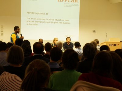 Moderator is standing and talking to the audience