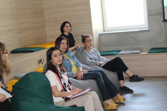 Group of sitting women are looking at something