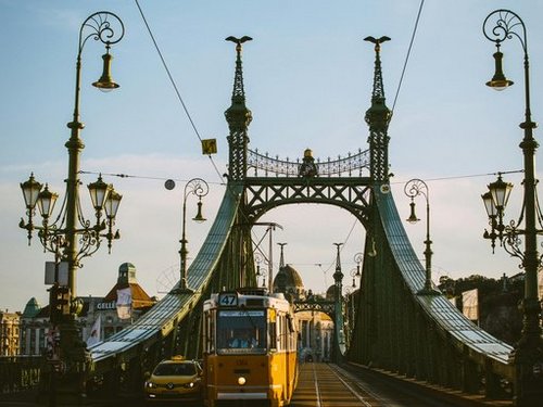 Eine gelbe Tram auf der Kettenbrücke in Budapest.