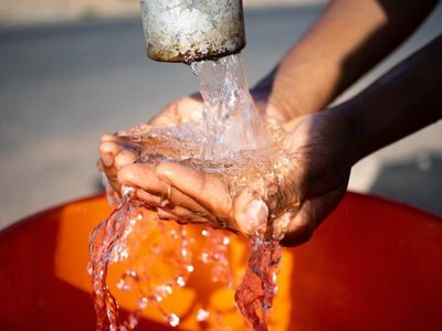 Hände unter laufendem Wasserhahn