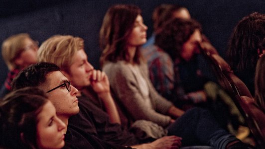 People in the cinema sitting and listening to the panellists