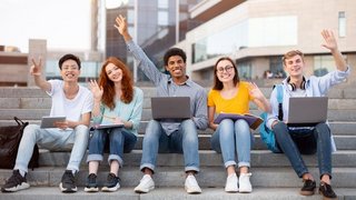 Happy Learning. Diverse group of teenagers waving and raising hands up in the air, sitting on steps with laptops and books