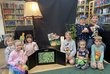 Gruppe Kinder am Boden vor Bücherregalen in Bibliothek