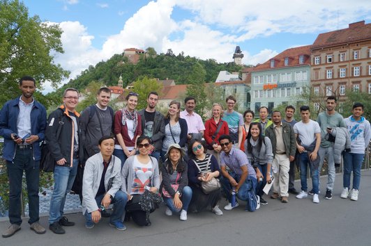 OeAD scholarship holders on an excursion in the old town of Graz with the clock tower.