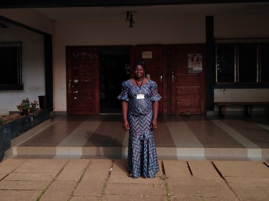 Young female student standing in front of university building