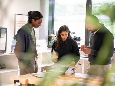 Drei Studierende beschäftigen sich mit einem technischen Projekt.