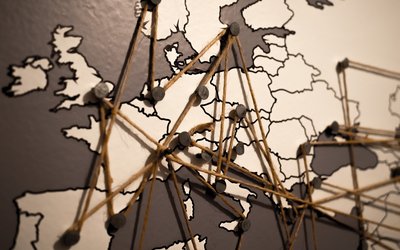 Foto einer Europakarte auf der viele Orte per Fäden miteinander verbunden sind
