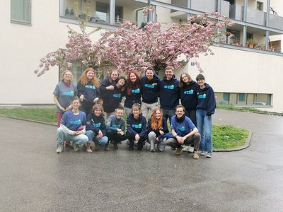 Gruppenbild von jungen Menschen die vor einem blühenden Baum stehen