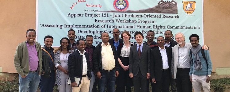 group foto of workshop participants with participants standing in front banner