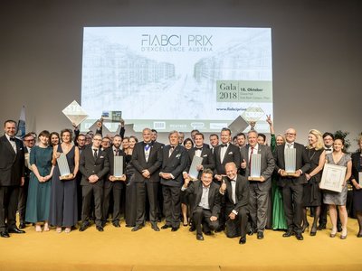 Verleihung des FIABCI Immobilienpreis 2018, Gruppe von Personen, die in die Kamera blicken, einige von ihnen halten einen Preis in der Gestalt eines Hochhauses, einige andere eine Urkunde in der Hand