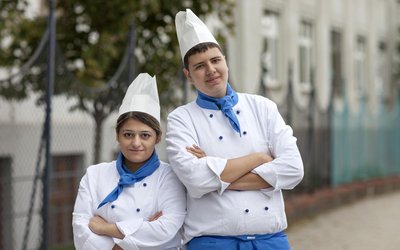 Junger Mann und junge Frau in Kochuniform