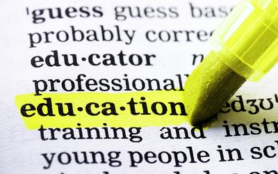 The picture shows an open dictionary, the word "education" is underlined by a yellow marker.