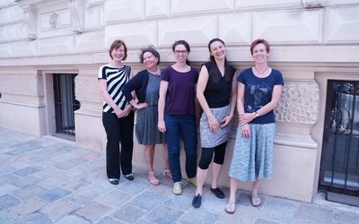 Maria Unger vom OeAD steht mit vier weiteren Damen an der Hauswand vor dem OeAD-Gebäude in Wien