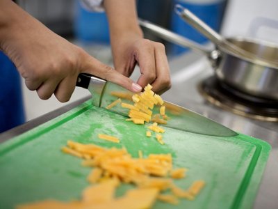 Nahaufnahme Hände schneiden Karotten in Küche