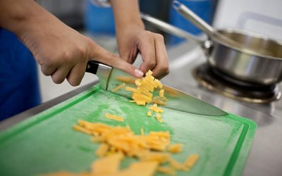 Nahaufnahme Hände schneiden Karotten in Küche