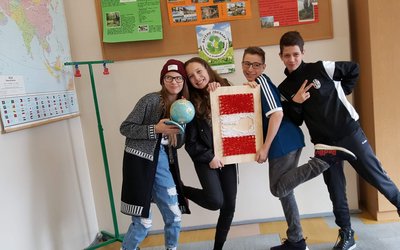  A group of students posing around a work of art.