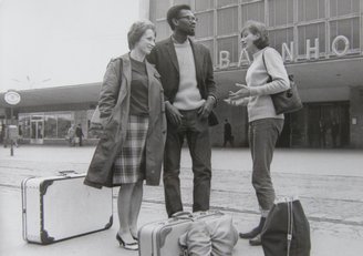 Zwei junge Frauen und ein junger Mann vor dem Wiener Westbahnhof in den 60er Jahren.  