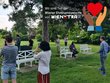 Menschen vermessen in einem Park mit den Smartphones Bäume. In das Bild ist das Logo der Wiener Ehrenamtswoche integriert.