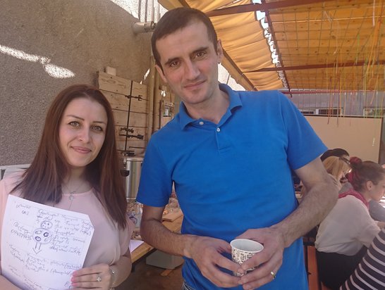 Scholarship holder Hasmik Hovakimyan holding her workshop notes and standing next to a workshop participant