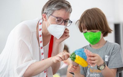 ein Kind und eine Forscherin arbeiten gemeinsam