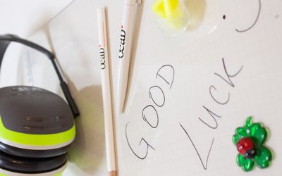 Schreibunterlagen mit Bleistift und Glücksbringer mit Schriftzug Good Luck