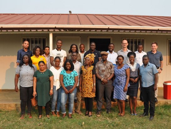 Group of people posing in front of a house for a group picture