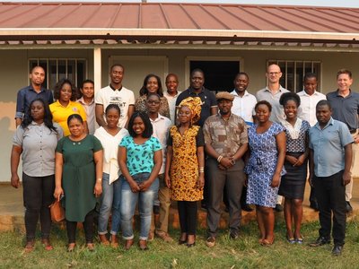 Group of people posing in front of a house for a group picture