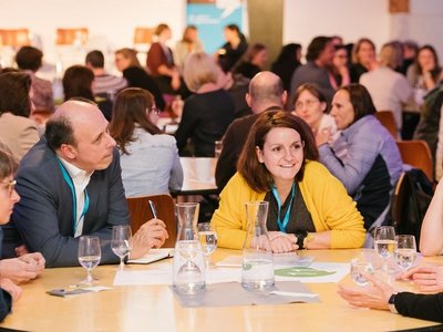 Mehrere Menschen sitzen zusammen an einem Tisch und tauschen sich aus