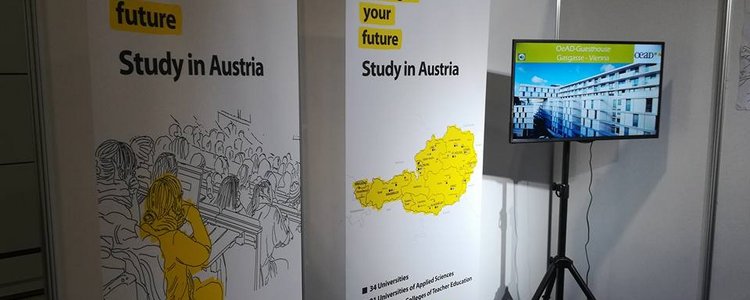 Der Österreichstand bei der Ghedex-Messe im Oman: Im Bild zwei Plakate mit Österreich-Motiven und ein großer Bildschirm.