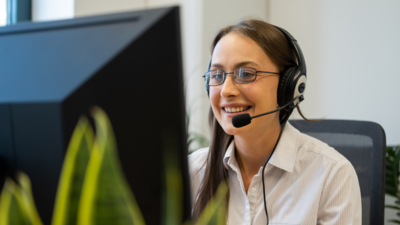 Frau mit Headset vor Computer