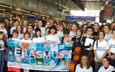 Gruppenfoto mit Schulkindern, die einen Banner mit dem Wort Erasmus halten. 