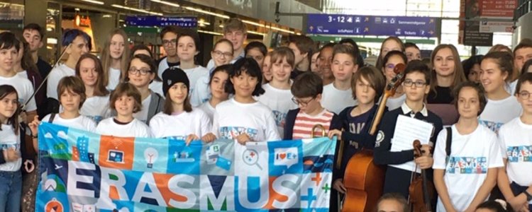 Gruppenfoto mit Schulkindern, die einen Banner mit dem Wort Erasmus halten. 