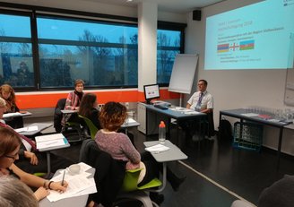 Group of sitting people looking at a presentation 