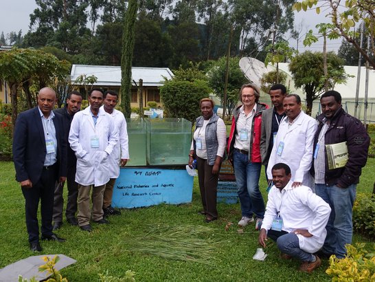 Scientists standing in the premises of the research center and posing next to aquarium 