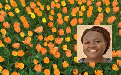 Portrait of Anne Birundi with yellow and orange tulips in the background