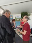 Zwei Männer im Austausch vor einem Infostand
