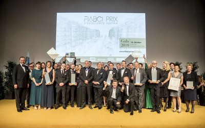 Verleihung des FIABCI Immobilienpreis 2018, Gruppe von Personen, die in die Kamera blicken, einige von ihnen halten einen Preis in der Gestalt eines Hochhauses, einige andere eine Urkunde in der Hand