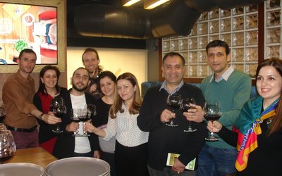 Team members raise their wine glasses to celebrate