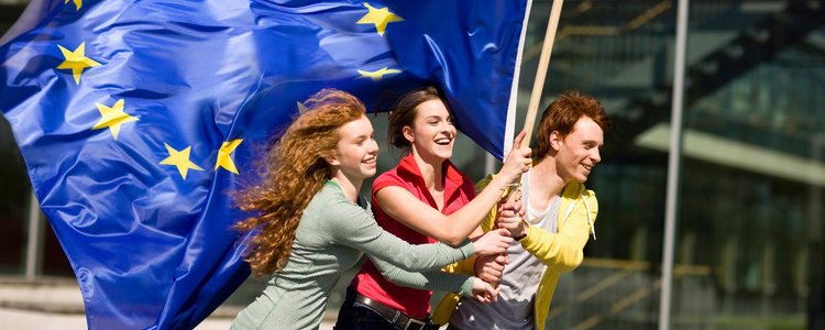 Drei junge Menschen laufen mit einer EU-Flagge
