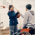 Male athlete with disability and his female friend congratulating each other after playing basketball on an outdoor court. Focus is on woman.